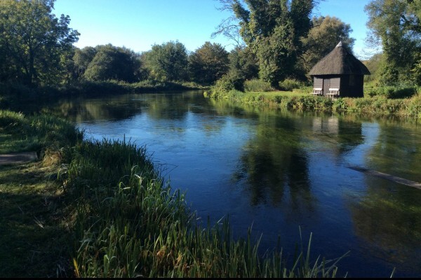 Sunny river with a fishing hut in the distance